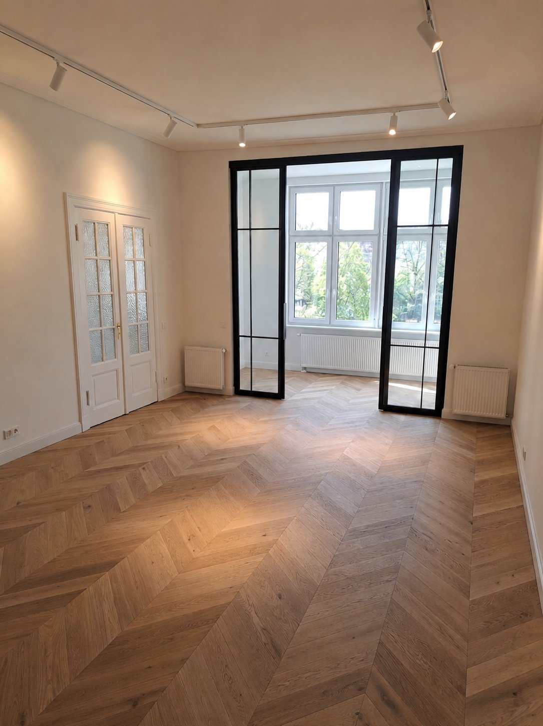 Raum mit Chevron-Parkett und Stahl-Glas-Element